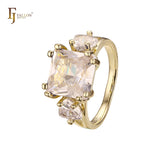 Anillo de compromiso en oro de 14 quilates con solitario de gran corte esmeralda y circonitas cúbicas coloridas en ambos lados, con dos circonitas blancas.