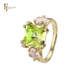 Anillo de compromiso en oro de 14 quilates con solitario de gran corte esmeralda y circonitas cúbicas coloridas en ambos lados, con dos circonitas blancas.