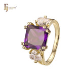 Anillo de compromiso en oro de 14 quilates con solitario de gran corte esmeralda y circonitas cúbicas coloridas en ambos lados, con dos circonitas blancas.