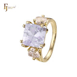 Anillo de compromiso en oro de 14 quilates con solitario de gran corte esmeralda y circonitas cúbicas coloridas en ambos lados, con dos circonitas blancas.