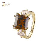 Anillo de compromiso en oro de 14 quilates con solitario de gran corte esmeralda y circonitas cúbicas coloridas en ambos lados, con dos circonitas blancas.
