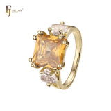 Anillo de compromiso en oro de 14 quilates con solitario de gran corte esmeralda y circonitas cúbicas coloridas en ambos lados, con dos circonitas blancas.