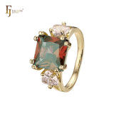 Anillo de compromiso en oro de 14 quilates con solitario de gran corte esmeralda y circonitas cúbicas coloridas en ambos lados, con dos circonitas blancas.