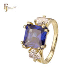 Anillo de compromiso en oro de 14 quilates con solitario de gran corte esmeralda y circonitas cúbicas coloridas en ambos lados, con dos circonitas blancas.