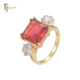 Anillo de compromiso en oro de 14 quilates con solitario de gran corte esmeralda y circonitas cúbicas coloridas en ambos lados, con dos circonitas blancas.
