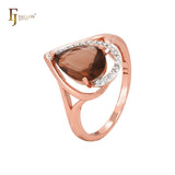 Anillo de moda en dos tonos de oro rosa con piedra café en forma de lágrima y circonitas blancas.